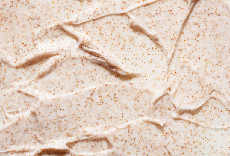 Irregular pattern of creamy organic scrub with brown grains Irregular pattern of creamy organic scrub with brown grains professional skincare product as background close view from above