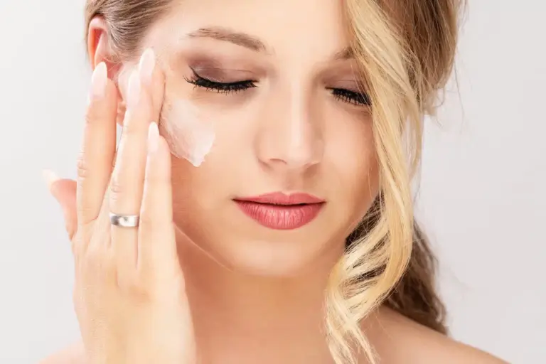 Woman applies cream to her beautiful skin