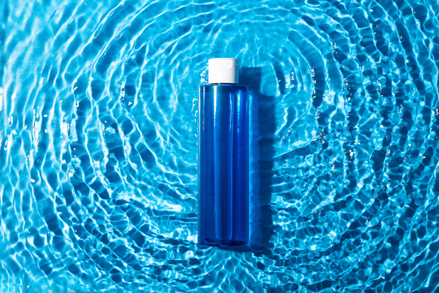 A bottle containing hyaluronic acid in water, illuminated by the sun